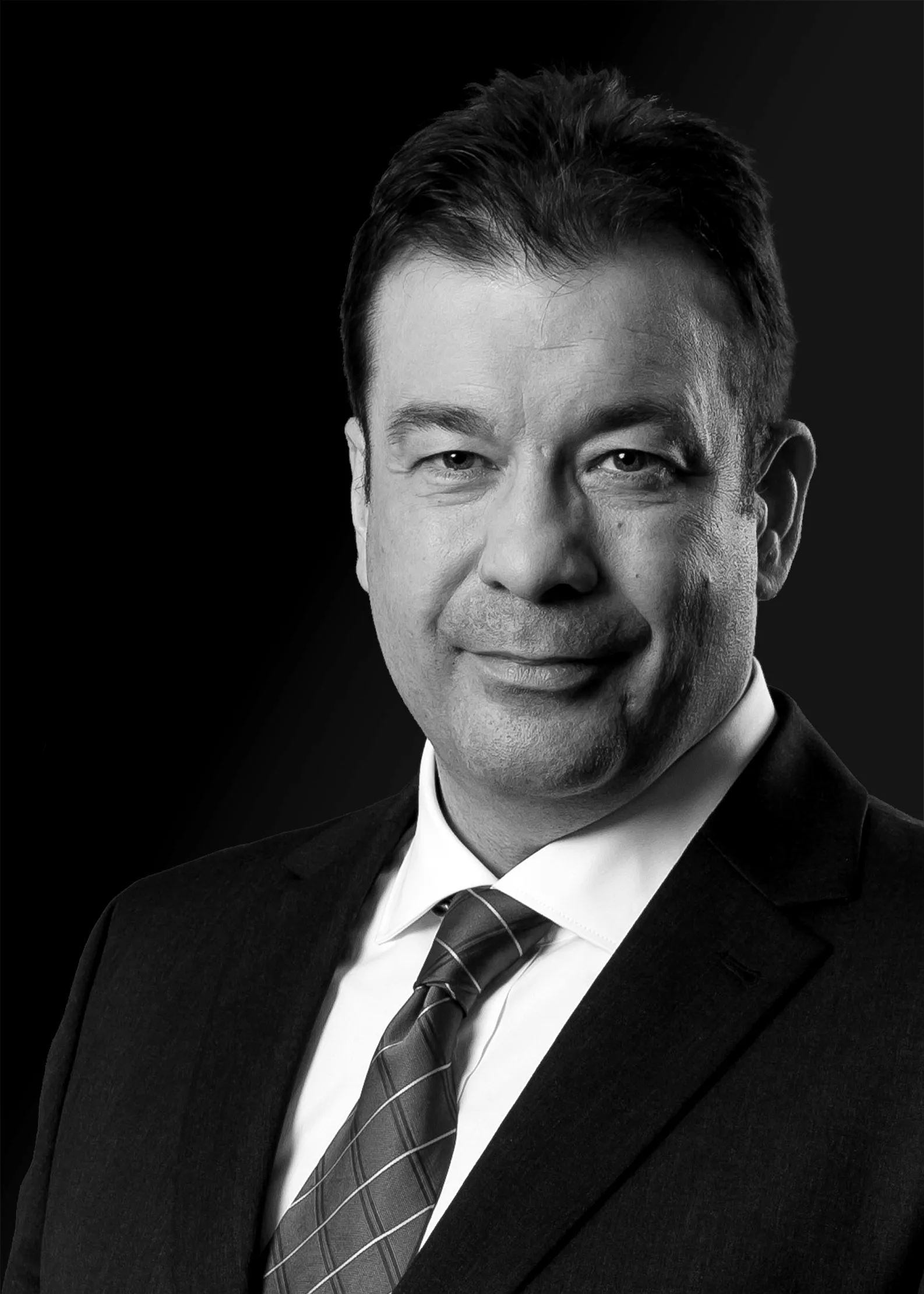 Black and white portrait of a man in a suit and tie against a dark background